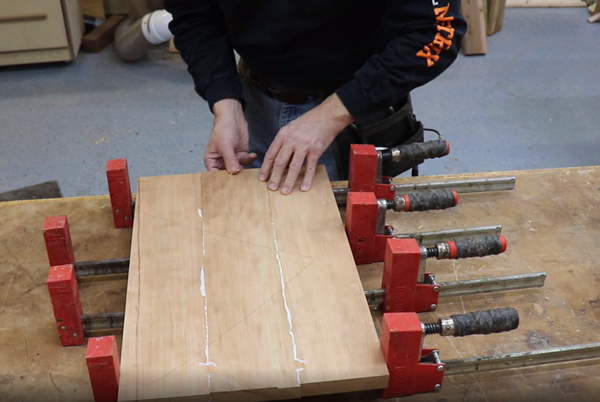 Finalizing wood panel by gluing pieces together and clamping